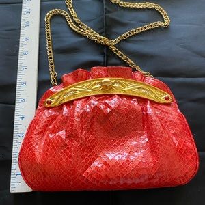 Elegant dyed red snake handbag w/ red leather lining. Gold frame w/knob lock.